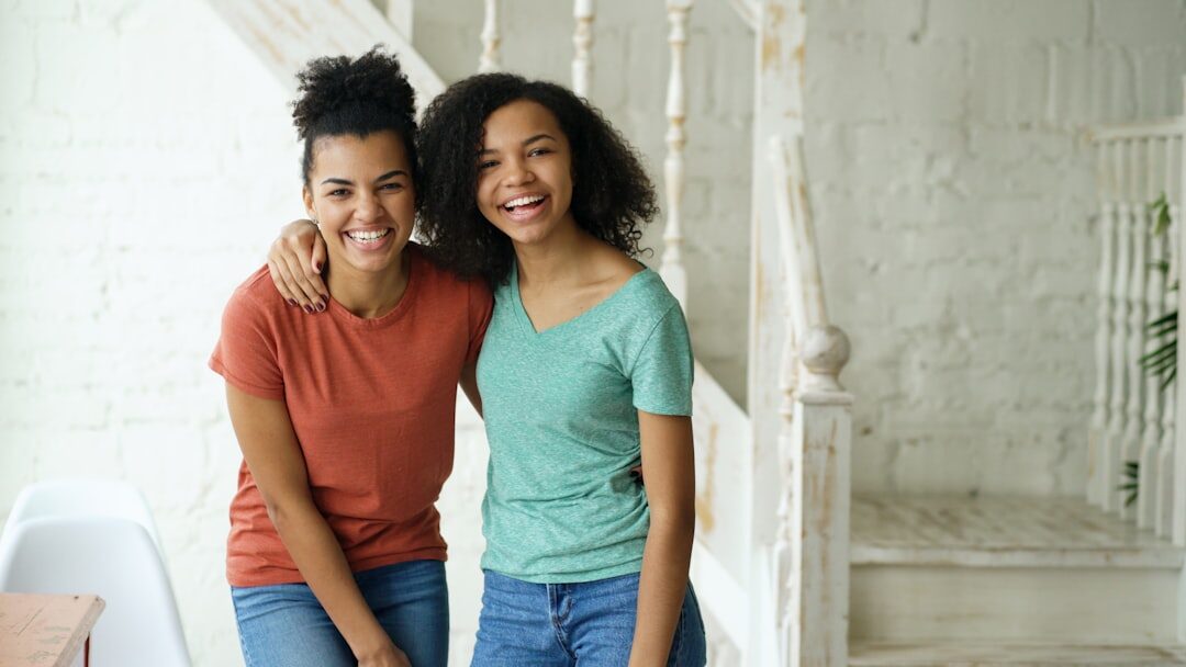 Adult daughter and senior mother smiling together at home